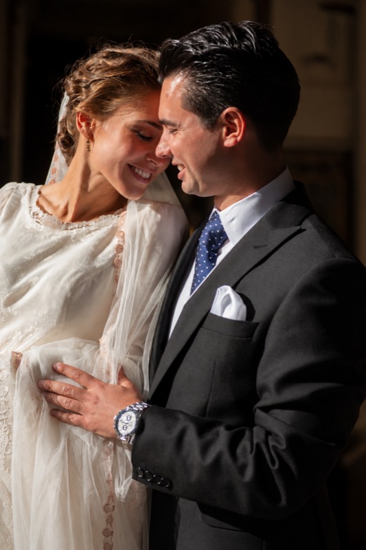 Los novios abrazados y riendo, con luz lateral, en una boda en Sevilla