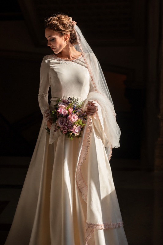 Retrato de novia con mantilla y ramo, con luz de ventana, en una boda en Sevilla